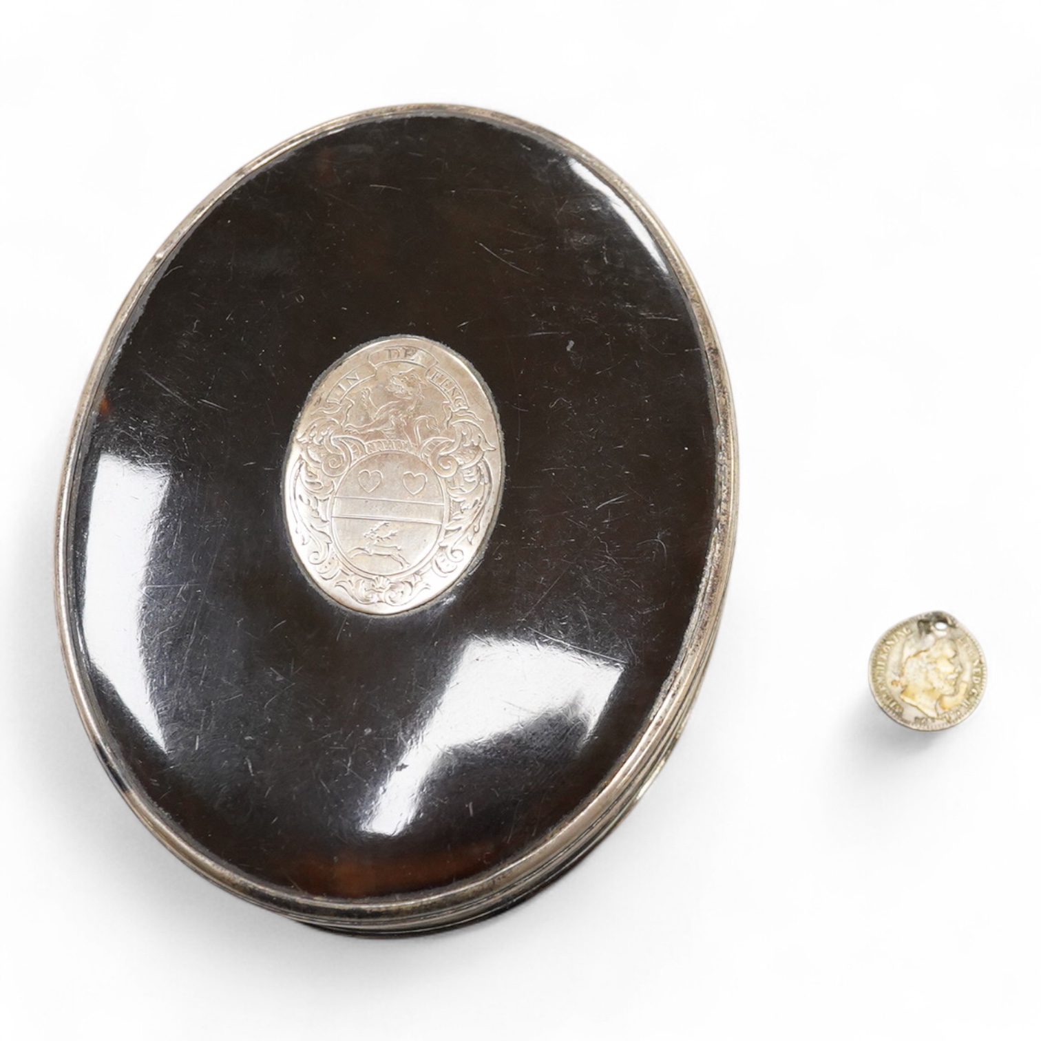 A 19th century white metal mounted tortoiseshell oval snuff box, with inset oval white metal plaque engraved with family crest, unmarked, 10.1cm.